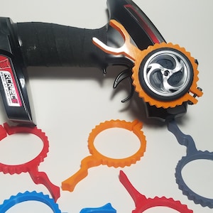 May include: A black remote control with an orange wheel attachment and four additional orange, red, and blue wheel attachments. The remote control has the text "RC926E REAL RACING" on the side.