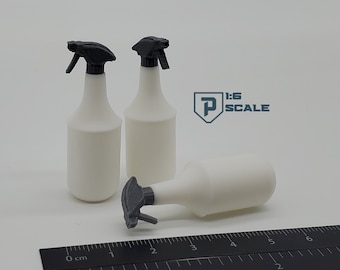 May include: Three white plastic spray bottles with black trigger tops. The bottles are 1:6 scale and are sitting on a black ruler.