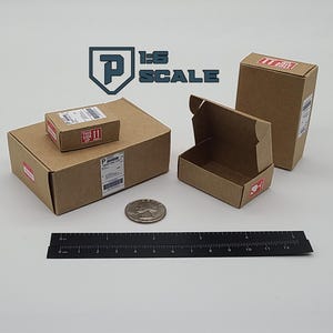 May include: Miniature brown cardboard boxes of various sizes, some with shipping labels and red "This Side Up" stickers. A ruler and a coin are also present, suggesting a scale of 1:6.