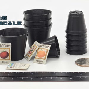 May include: Black plastic miniature plant pots, seed packets, and a ruler. The seed packets are labeled with images of tomatoes, radishes, and pumpkins. A quarter is included for scale. The text "1:6 SCALE" is visible.