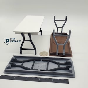 K&ouml;nnte beinhalten: Ein wei&szlig;er Klapptisch mit schwarzen Metallbeinen. Der Tisch ist im Ma&szlig;stab 1:12 und wird zusammengeklappt gezeigt. Der Tisch ist aus Kunststoff und f&uuml;r die Verwendung mit Miniaturfiguren konzipiert.