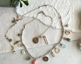 Colar com pingente folheado a ouro: pérola, pedra preciosa e símbolo Ohm