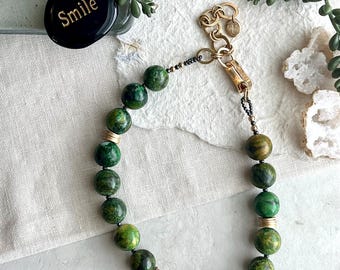 Colar statement com contas de gnaisse verde e fecho de latão reciclado e bronze.