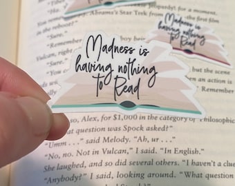 Può includere: Un adesivo con un design di libro e il testo "Madness is having nothing to read".
