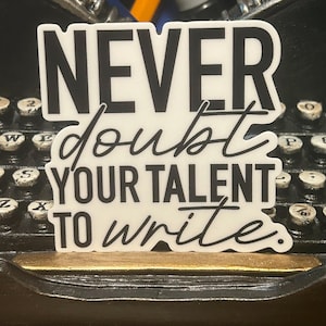 May include: White sticker with black text that reads "NEVER doubt YOUR TALENT TO write."