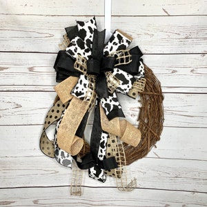 Black and White Cow Bow on an eighteen inch wreath with a distressed wood photography background.  The Grapevine wreath is for display only and not for sale. Refer to the listing description for further bow details.