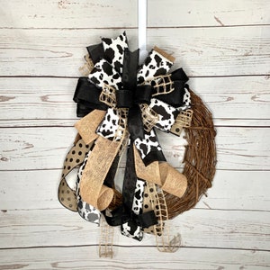 Black and White Cow Bow on an eighteen inch wreath with a distressed wood photography background.  The Grapevine wreath is for display only and not for sale. Refer to the listing description for further bow details.