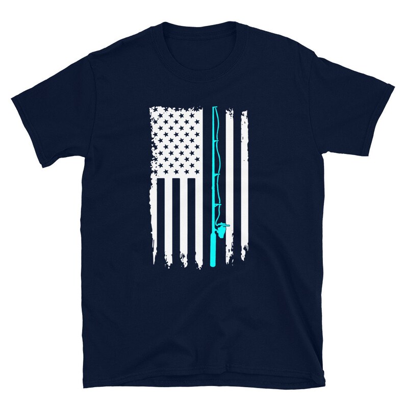 May include: Navy blue t-shirt featuring a distressed American flag design with a light blue fishing rod graphic. The flag has white stripes and stars. A great gift for fishing enthusiasts.