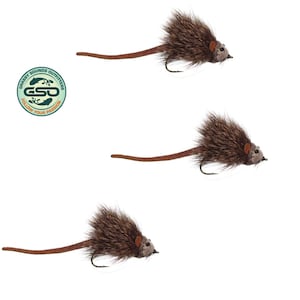 May include: Three brown and tan fishing flies shaped like mice. Each fly has a dark brown body, a tan tail, and a small hook. The flies are set against a white background. The Grassy Sounds Outfitters logo is in the upper left corner.