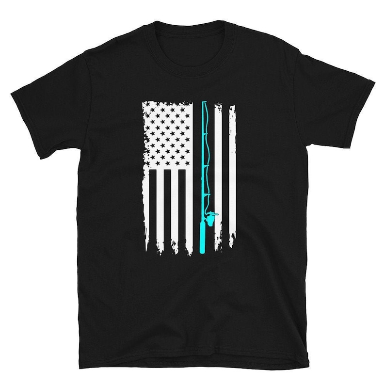 May include: Black t-shirt featuring a distressed American flag design with a light blue fishing rod graphic. The flag's stars are white, and the stripes are white and black. The fishing rod is vertically aligned on the right side of the flag.