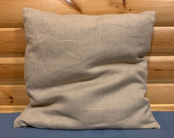 May include: A plain, beige linen pillow with a zipper closure. The pillow is sitting on a blue surface.