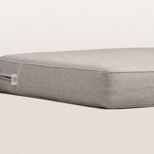 May include: A gray rectangular dog bed with a zipper on one side.