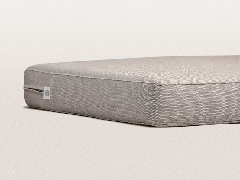 May include: A gray rectangular dog bed with a zipper on one side.