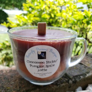 K&ouml;nnte beinhalten: Eine Kerze in einem transparenten Glasbecher mit braunem Wachs und einem Holzdocht. Die Kerze ist mit "Cinnamon Sticks/Pumpkin Spice Latte" von Butterfly Dreams Boutique beschriftet. Die Kerze ist 454g.