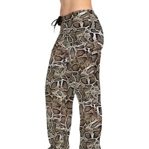 May include: Brown and tan snake skin print pajama pants. The pants have a drawstring waistband and a relaxed fit.