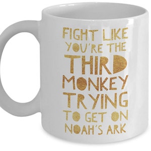 May include: White ceramic coffee mug with a gold inscription that reads "Fight like you're the third monkey trying to get on Noah's Ark."