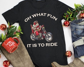 May include: Black t-shirt with a graphic of Santa Claus riding a motorcycle. The text "Oh What Fun It Is To Ride" is printed on the shirt.