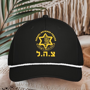 May include: Black baseball cap with a white rope detail on the brim. The cap features the words "ISRAEL DEFENSE FORCES" and a star emblem in yellow. Below the emblem is Hebrew text in yellow.
