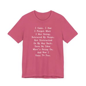 May include: A short-sleeved, magenta t-shirt with white text. The text reads: "I Came, I Saw, I Forgot What I Was Doing, Retraced My Steps, Got Distracted On My Way Back, Have No Idea What's Going On, And Now I Have To Pee."