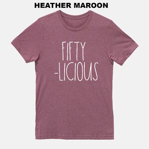 May include: Heather maroon t-shirt with white text that reads "Fifty -licious".