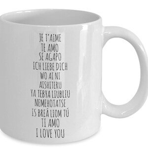 May include: White ceramic coffee mug with black text that reads "Je t'aime", "Te amo", "Se Agapo", "Ich liebe dich", "Wo ai ni", "Aishiteru", "Ya tebya liubliu", "Nemehotatse", "Is bre&aacute; liom t&uacute;", "Ti amo", "I love you".