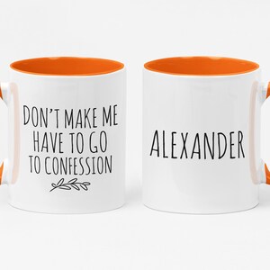 May include: Two white ceramic mugs with orange interiors and handles. One mug reads "DON'T MAKE ME HAVE TO GO TO CONFESSION" with a leaf design. The other mug has the name "ALEXANDER" in black text.