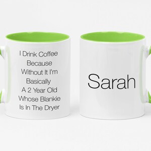 May include: White ceramic coffee mug with a green rim and handle. The mug has text that reads "I Drink Coffee Because Without It I'm Basically A 2 Year Old Whose Blankie Is In The Dryer". The other side of the mug has the name "Sarah" printed on it.