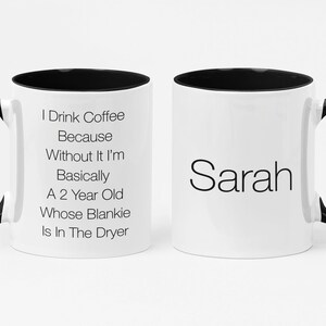 May include: White ceramic coffee mug with a black rim and handle. The mug has black text that reads "I Drink Coffee Because Without It I'm Basically A 2 Year Old Whose Blankie Is In The Dryer". The other side of the mug has the name "Sarah" in black text.