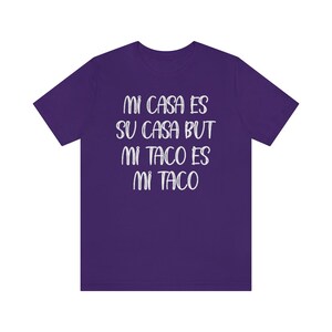 Puede incluir: Camiseta morada con el texto "Mi casa es su casa but mi taco es mi taco" en blanco.