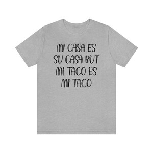 Puede incluir: Camiseta gris con el texto "Mi casa es su casa but mi taco es mi taco" impreso en negro.