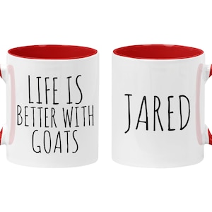 May include: Two white ceramic mugs with red interiors. One mug says "Life is better with goats" and the other mug says "JARED".