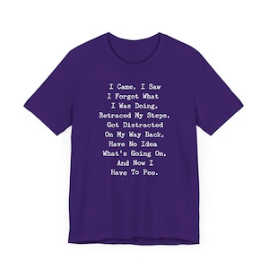 May include: A purple t-shirt with white text. The text reads: "I Came, I Saw, I Forgot What I Was Doing, Retraced My Steps, Got Distracted On My Way Back, Have No Idea What's Going On, And Now I Have To Pee."