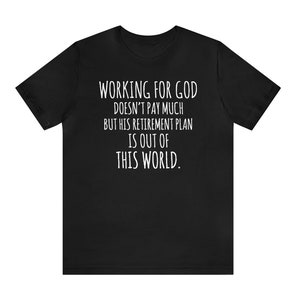 May include: Black t-shirt with white text that reads "WORKING FOR GOD DOESN'T PAY MUCH BUT HIS RETIREMENT PLAN IS OUT OF THIS WORLD."