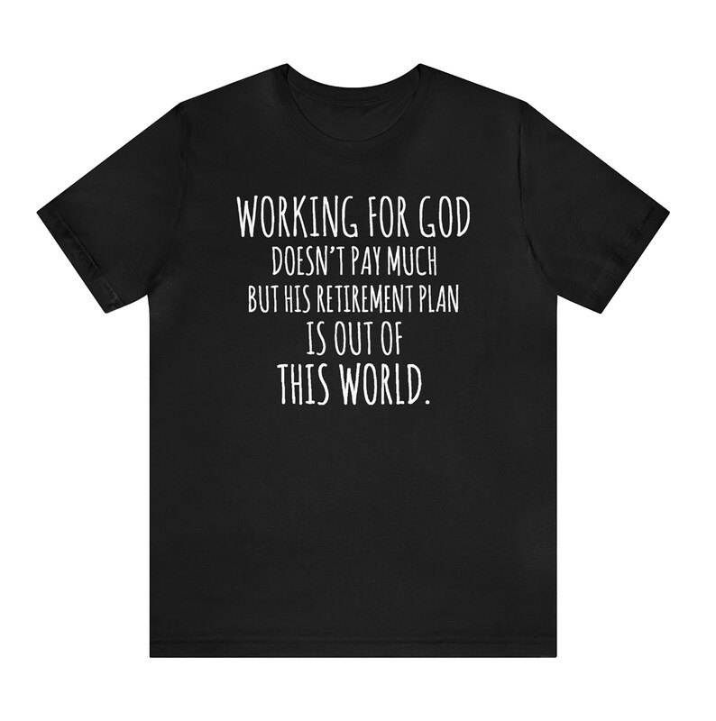May include: Black t-shirt with white text that reads "WORKING FOR GOD DOESN'T PAY MUCH BUT HIS RETIREMENT PLAN IS OUT OF THIS WORLD."