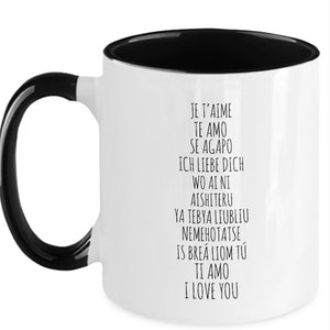 May include: White ceramic coffee mug with a black interior and handle. The mug features black text that reads "Je t'aime", "Te amo", "Se Agapo", "Ich liebe dich", "Wo ai ni", "Aishiteru", "Ya tebya lyublyu", "Nemehotatse", "Is brea liom tu", "Ti amo", and "I love you".