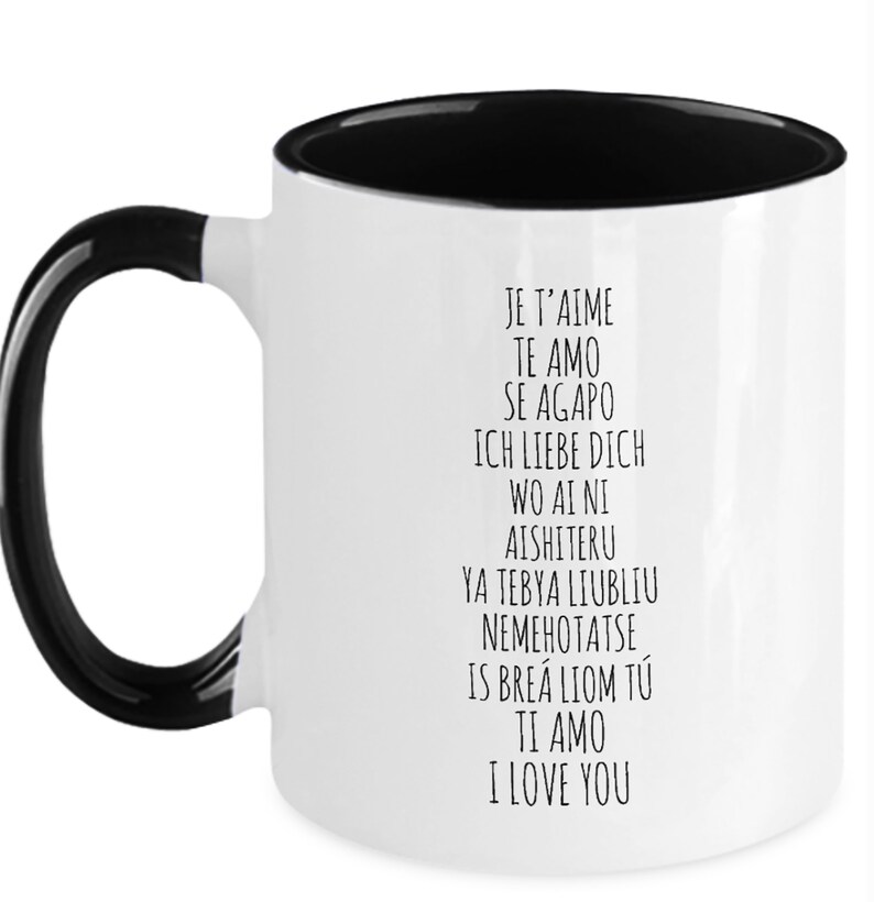 May include: White ceramic coffee mug with a black interior and handle. The mug features black text that reads "Je t'aime", "Te amo", "Se Agapo", "Ich liebe dich", "Wo ai ni", "Aishiteru", "Ya tebya lyublyu", "Nemehotatse", "Is brea liom tu", "Ti amo", and "I love you".