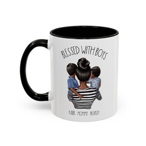 Puede incluir: Taza de cer&aacute;mica blanca con borde y asa negros. La taza tiene una ilustraci&oacute;n en blanco y negro de una madre con dos hijos. El texto "Blessed with Boys" est&aacute; impreso en la taza, junto con los nombres "Kabir, Mommy, Aakash".
