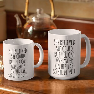 Puede incluir: Dos tazas de cer&aacute;mica blanca con texto negro. El texto en las tazas dice "Ella cre&iacute;a que pod&iacute;a, pero su gato estaba dormido en su regazo... as&iacute; que no lo hizo."