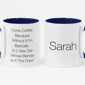 May include: White coffee mug with a blue rim and handle. The mug has text that reads "I Drink Coffee Because Without It I'm Basically A 2 Year Old Whose Blankie Is In The Dryer". The other side of the mug has the name "Sarah" written in black.