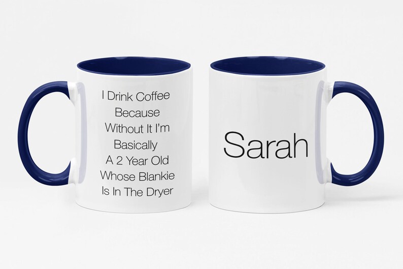 May include: White coffee mug with a blue rim and handle. The mug has text that reads "I Drink Coffee Because Without It I'm Basically A 2 Year Old Whose Blankie Is In The Dryer". The other side of the mug has the name "Sarah" written in black.