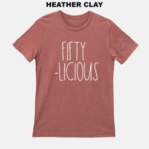 May include: A heather clay t-shirt with the text "FIFTY -LICIOUS" in white.