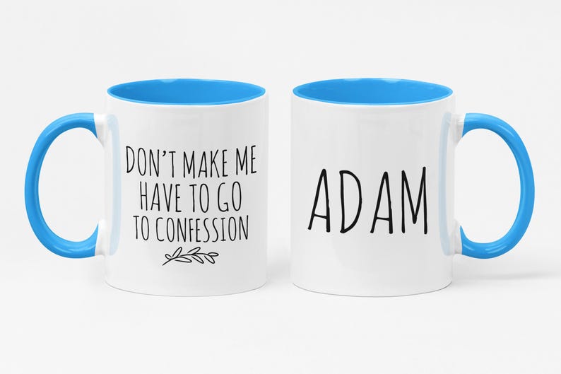 May include: Two white ceramic mugs with blue interiors and handles. One mug has the text "DON'T MAKE ME HAVE TO GO TO CONFESSION" and a small leaf design. The other mug has the name "ADAM" in black text.
