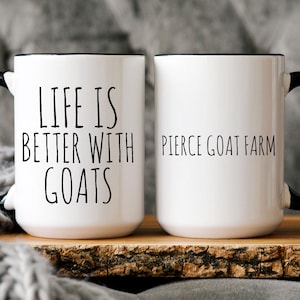 May include: Two white ceramic mugs with black handles and black rims. One mug says "Life is better with goats" and the other mug says "Pierce Goat Farm".