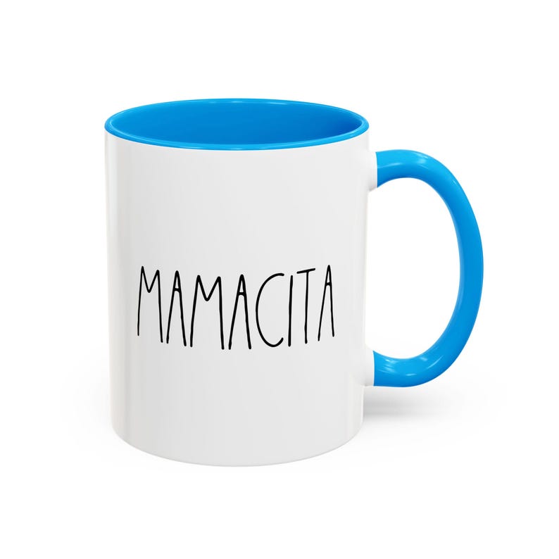 May include: White ceramic mug with a blue interior and handle. The word "Mamacita" is printed in black, handwritten-style font on the front of the mug. A simple, yet stylish design for everyday use.