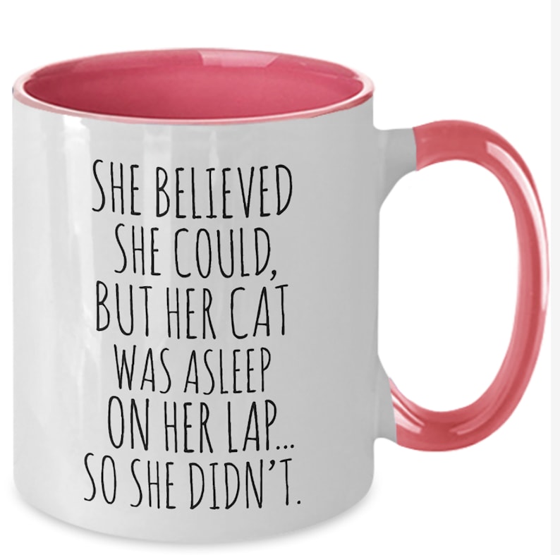 Puede incluir: Taza de caf&eacute; de cer&aacute;mica blanca con borde y asa de color rosa. La taza tiene un dicho divertido impreso: "Ella cre&iacute;a que pod&iacute;a, pero su gato estaba dormido en su regazo... as&iacute; que no lo hizo."