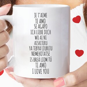 May include: White ceramic mug with black text that reads "Je t'aime, Te amo, Se agapo, Ich liebe dich, Wo ai ni, Aishiteru, Ya tebya lyublyu, Nemehotatse, Is bre&aacute; liom t&uacute;, Ti amo, I love you".