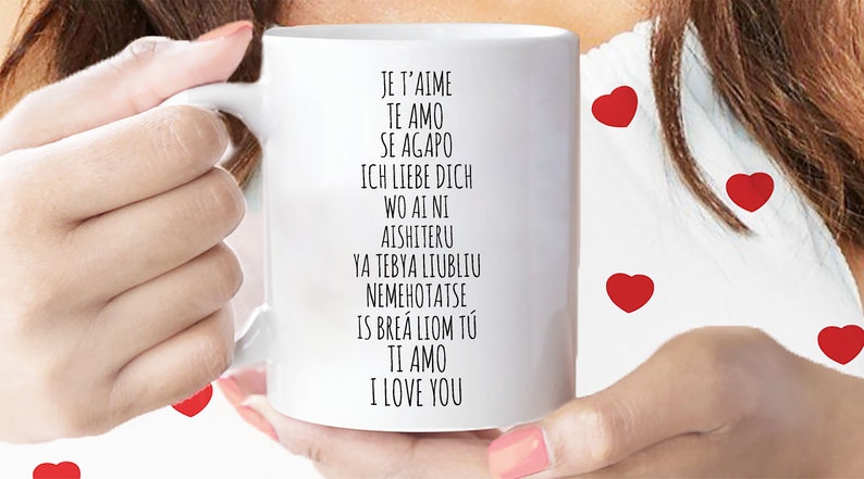 May include: White ceramic mug with black text that reads "Je t'aime, Te amo, Se agapo, Ich liebe dich, Wo ai ni, Aishiteru, Ya tebya lyublyu, Nemehotatse, Is bre&aacute; liom t&uacute;, Ti amo, I love you".