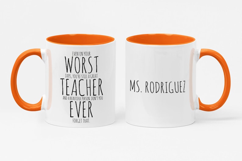 May include: White ceramic mug with an orange interior and handle. The mug features the text "EVEN ON YOUR WORST DAYS, YOU'RE STILL A GREAT TEACHER" on one side and "MS. RODRIGUEZ" on the other. A thoughtful gift for a teacher.