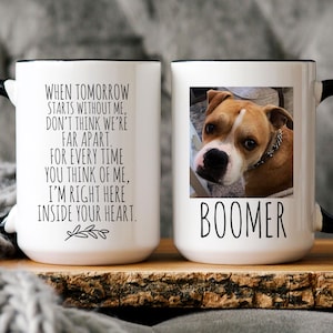 May include: White ceramic coffee mug with a black handle and rim. The mug has a black and white photo of a brown and white dog with the name "Boomer" printed below the photo. The mug also has a quote printed on it that reads: "When tomorrow starts without me, don't think we're far apart. For every time you think of me, I'm right here inside your heart."