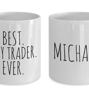 Puede incluir: Dos tazas de cer&aacute;mica blanca. Una taza dice "Best Day Trader Ever." La otra taza dice "Michael."